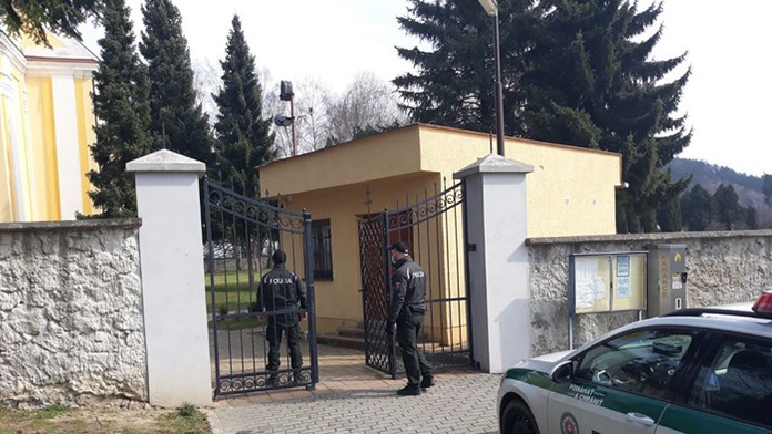 Policajti pre kostolom v Trenčianskej Teplej.
