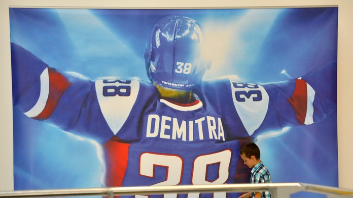 Chlapec sa fotí pri filmovom plagáte s fotografiou Pavla Demitru k filmu "38 filmová pocta hokejovej legende".