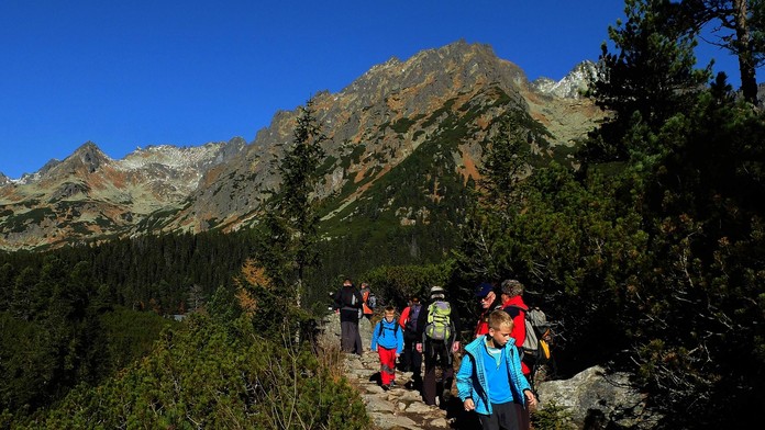 Turisti kráčajú po chodníku v okolí Popradského plesa 