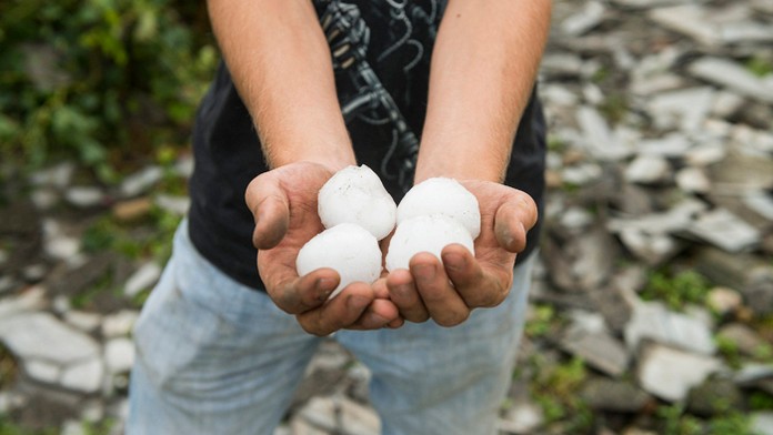 Obyvateľ maďarskej dediny Rozsály drží v rukách ľadové krúpy, ktoré padali počas búrky.