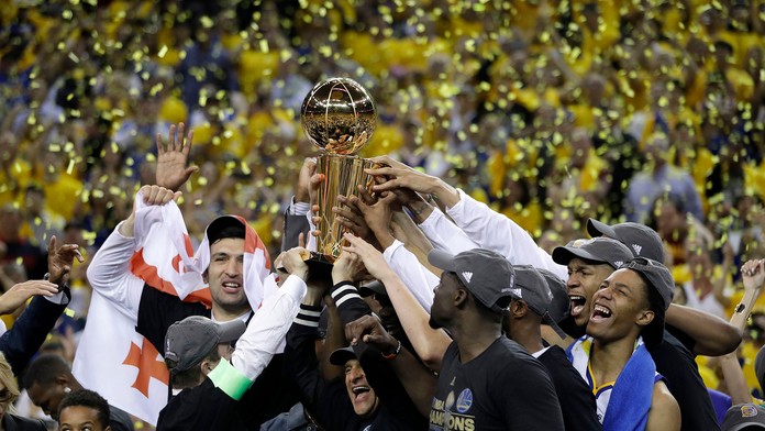 Basketbalisti Golden State Wariors s trofejou nad hlavami oslavujú víťazstvo v NBA po výhre nad Cleveland Cavaliers.