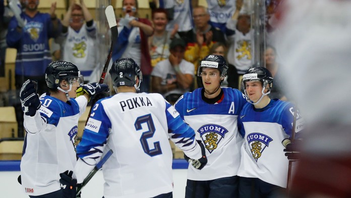 Sebastian Aho (druhý sprava) oslavuje s fínskymi spoluhráčmi gól v lotyšskej sieti v dueli MS 2018.