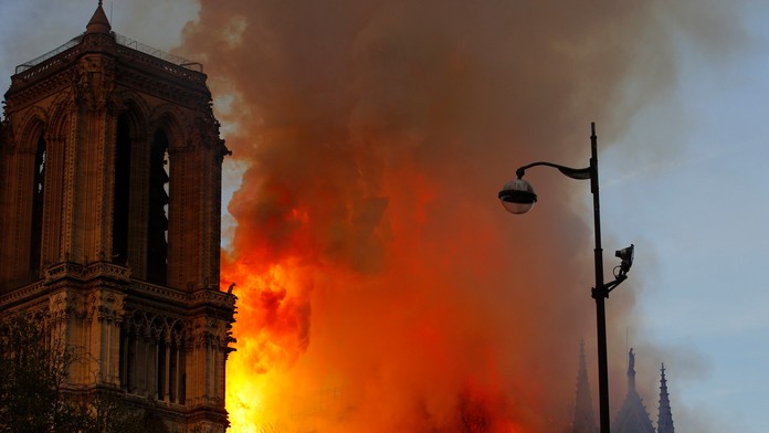 Hasič hasí požiar katedrály Notre Dame.