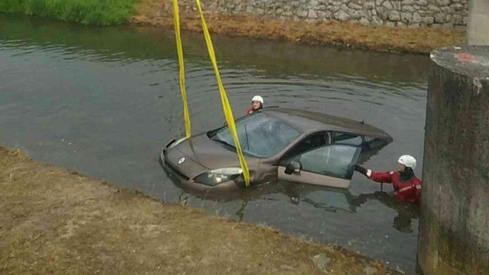 Hasiči vyťahujú uviaznuté auto v potoku v Bánovciach nad Bebravou.