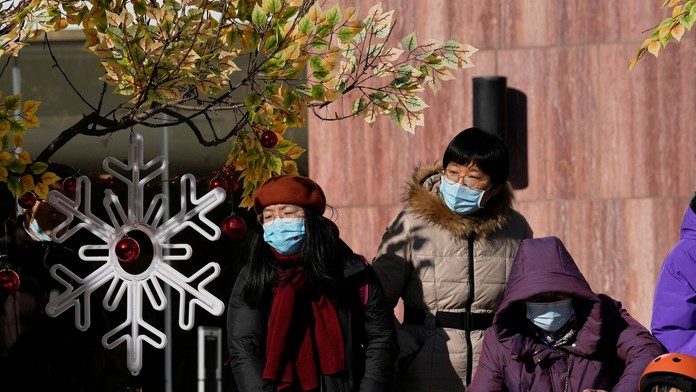 Číňania s ochrannými rúškami na tvári prichádzajú do nákupného centra v Pekingu.