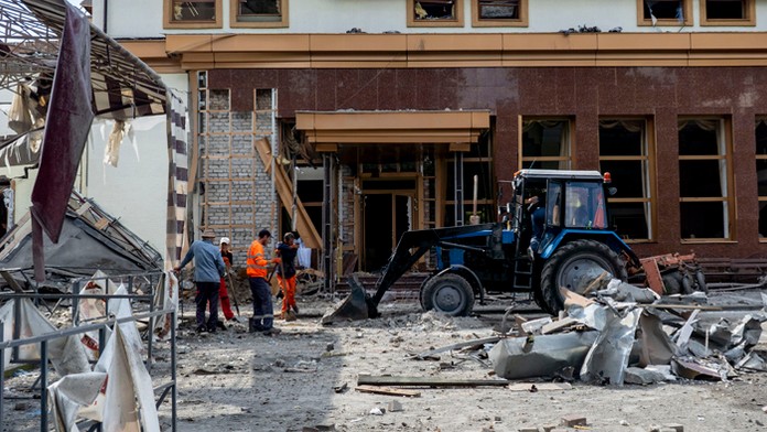 Pracovníci odpratávajú trosky zničeného hotela v centrálnom parku v ukrajinskom Záporoží.