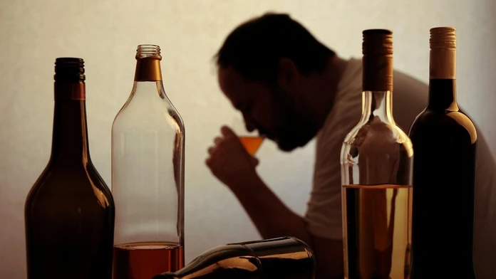 Muž pije alkohol. 