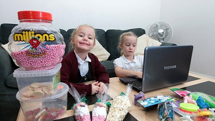 Elizabeth (7) predáva hračky a jej mladšia sestra Rebecca (4) sladkosti