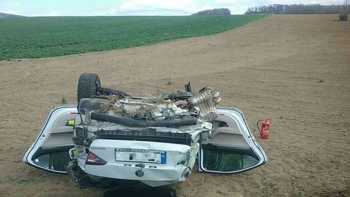 Po zrážke s nákladiakom skončilo osobné auto v poli prevrátené na streche