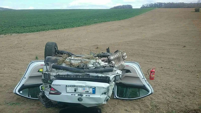 Po zrážke s nákladiakom skončilo osobné auto v poli prevrátené na streche