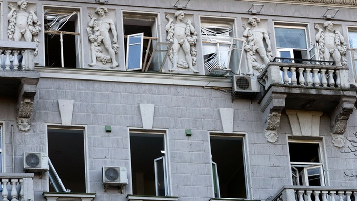 Rozbité sklá na oknách historickej budovy po ruskom raketovom útoku v Kyjeve.
