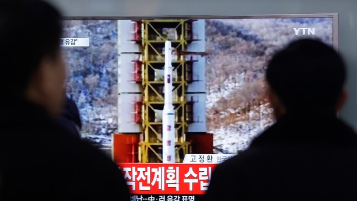  Ľudia sledujú televízne spravodajstvo o vypustení rakety dlhého doletu.