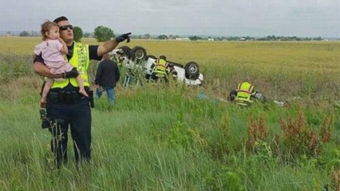 Táto fotografia obletela svet. Policajt rozptyľoval dievčatko, zatiaľ čo jej mŕtveho otca vyťahovali z havarovaného auta.