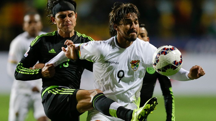 Mexický hráč Gerardo Flores (vľavo) a v súboji s Bolivíjčanom Marcelo Morenom na Copa America.