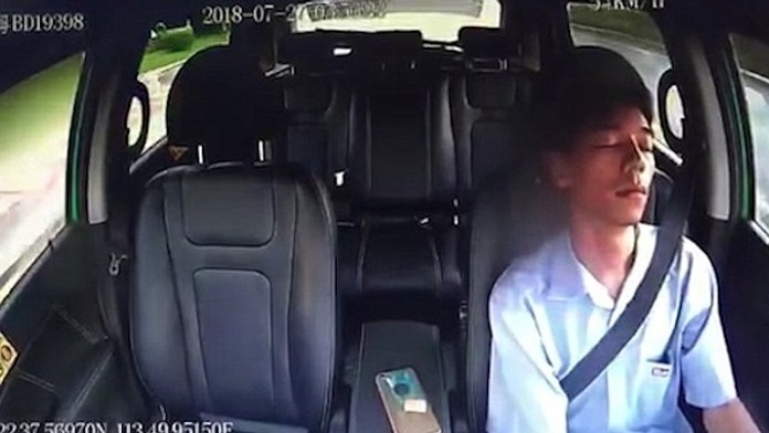 Spiaci taxikár v idúcom aute v Číne