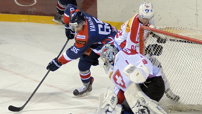 Slovák Michael Vandas sa znaží dostať puk za švajčiarskeho brankára Tima Wolfa. 