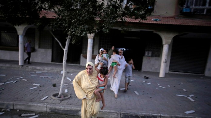 Ľudia utekajú po zrútení 13-poschodového domu v Gaze.