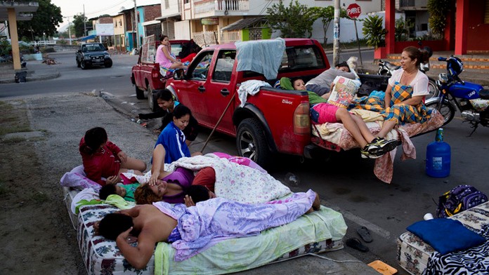 Rodina sa zobúdza na matracoch po tom, ako spali pred ich zrúteným domom po silnom zemetrasení.