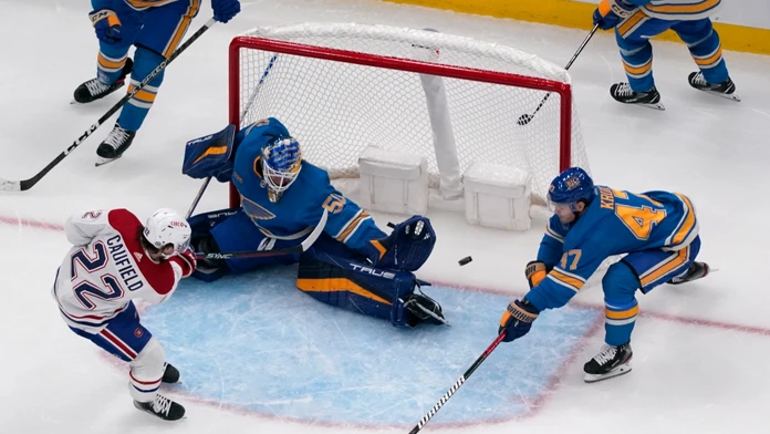 Hokejista Montrealu Canadiens Cole Caufield (vľavo) prekonáva brankára St. Louis Blues Jordana Binningtona