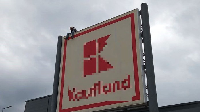 Muž na streche obchodného centra.