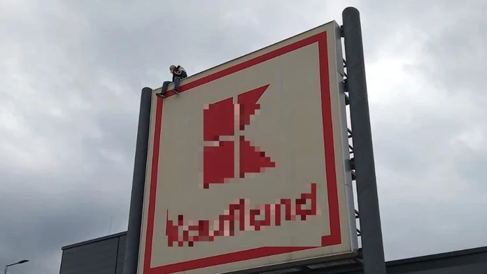 Muž na streche obchodného centra.
