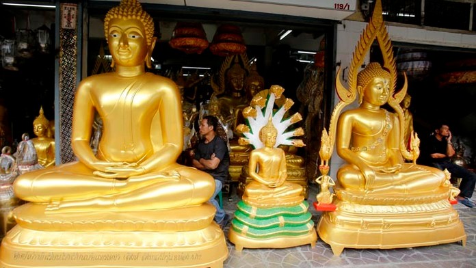 Na snímke thajskí predavači sedia vedľa sôch Budhov a čakajú na zákazníkov v Bangkoku.