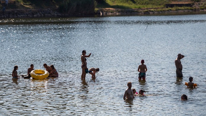 Na snímke ľudia sa kúpu vo vodnej nádrži v obci Kuchyňa.