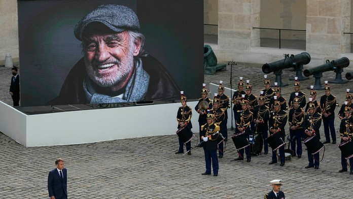 Prezident E. Macron prechádza okolo portrétu Jeana-Paula Belmonda po pietnej rozlúčke.