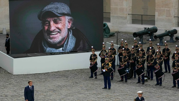 Prezident E. Macron prechádza okolo portrétu Jeana-Paula Belmonda po pietnej rozlúčke.