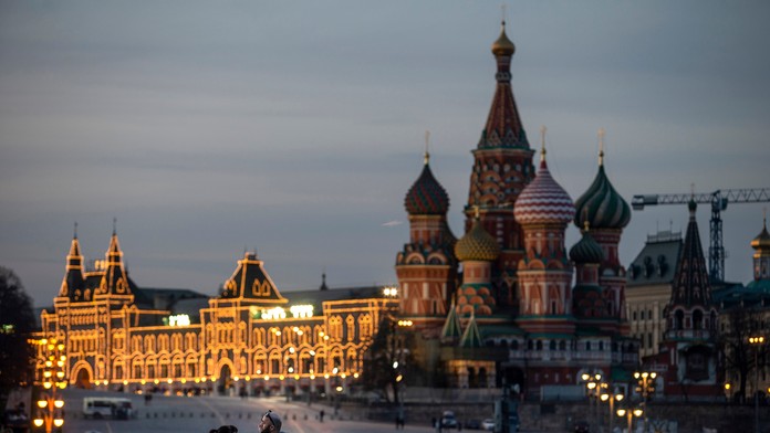 Muž kráča po moste cez rieku Mohan s budovou Európskej centrálnej banky (ECB) v pozadí vo Frankfurte nad Mohanom.