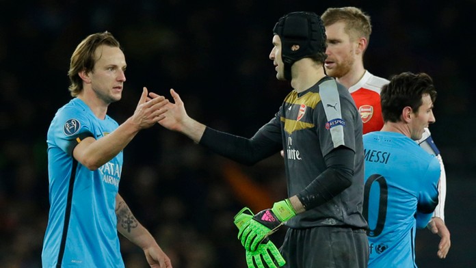 Brankár Arsenalu Petr Čech si podáva ruku s Ivom Rakitičom, v pozadí Lionel Messi.