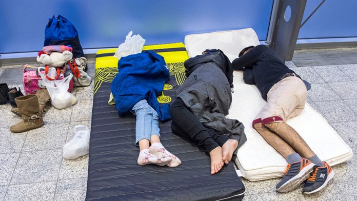 Utečenci, ktorých transportovali autobusmi z Mníchova, spia vo výstavných priestoroch veľtrhu v Erfurte.