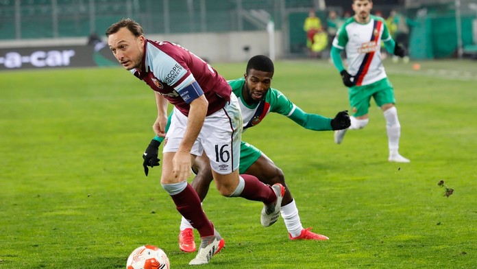 Mark Noble (West Ham) v súboji o loptu s Kelvinom Arasem z Rapidu Viedeň.