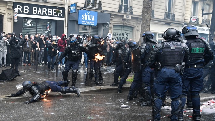 NA snímke sú zachytené demonštrácie vo Francúzku. Na fotke sú demonštranti aj policajti. Jeden z policajtov leží na zemi.