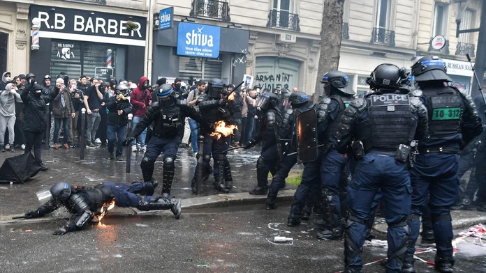 NA snímke sú zachytené demonštrácie vo Francúzku. Na fotke sú demonštranti aj policajti. Jeden z policajtov leží na zemi.