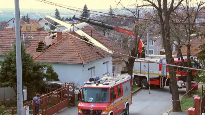 Hasiči dávajú dole zo strechy vetroňa, ktorý pristál na streche domu na Zobore.
