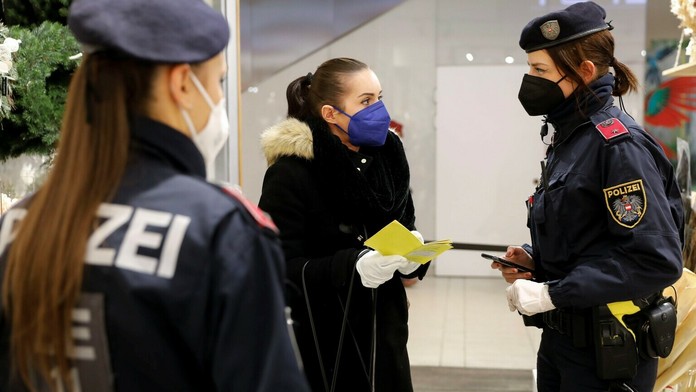 Policajtka kontroluje očkovací preukaz zákazníčky vo Viedni.