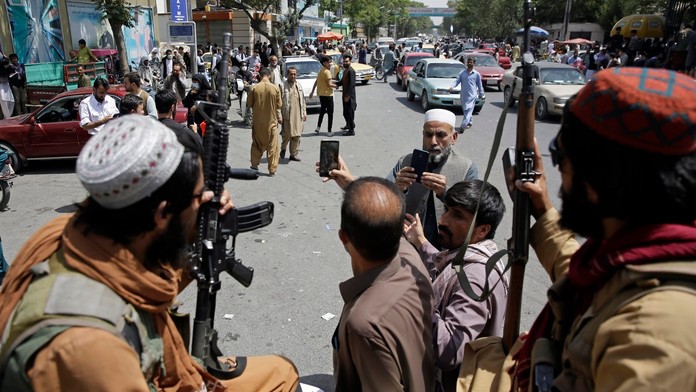 Afganci si fotia selfie s bojovníkmi Talibanu, ktorí hliadkujú na ulici v Kábule.