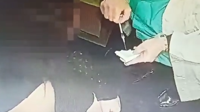 Sestrička vyprázdňuje očkovaciu látku do obväzu.