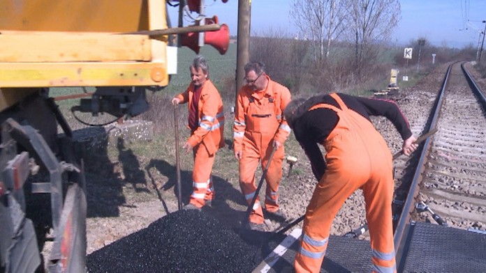 Železničiari opravujúci trať.