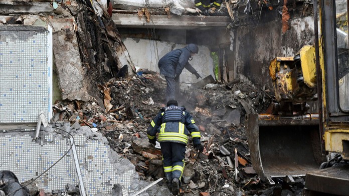 Záchranári pracujú na mieste bytovky zničenej ruským ostreľovaním v Bachmute.