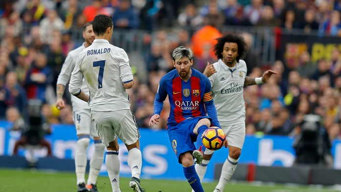 Kapitána Barcelony Lionela Messiho (v strede) sa v El Clásicu snaží obrať o loptu bek Realu Marcelo (vpravo), prizerá sa Cristia