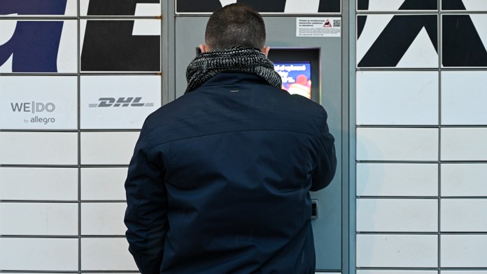 Na snímke je muž, ktorý si vyberá tovar s výdajného boxu. 