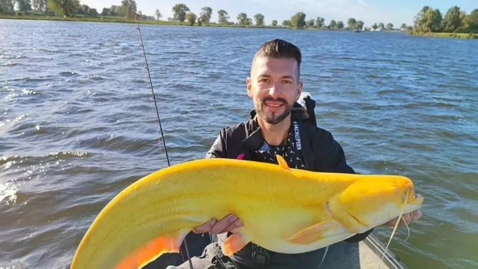 Rybár pózuje s unikátnym úlovkom.