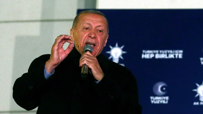 Turecký prezident Recep Tayyip Erdogan s mikrofónom v ruke počas prejavu.