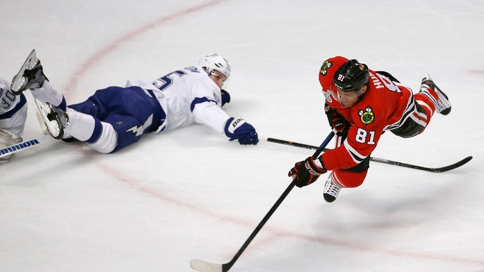 Marián Hossa sa v páde snaží prekonať Bena Bishopa.