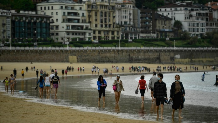 Ľudia kráčajú po pláži po zrušení lockdownu v severošpanielskom meste San Sebastian v nedeľu 9. mája 2021.