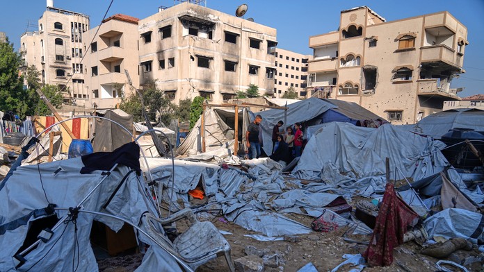 Palestínčania prehľadávajú zničené stany po izraelskom leteckom útoku na stanovú osadu, kde sa nachádzali vojnoví utečenci v centre mesta Gaza.