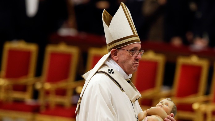 Pápež František počas polnočnej omši vo Vatikáne drží v rukách Ježiša Krista.