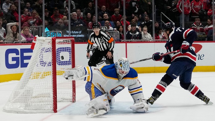 Hráč Capitals T.J. Oshie strieľa víťazný gól, vľavo prekonaný fínsky brankár Buffala Ukko-Pekka Luukkonen.